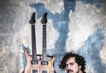 Persische Musik trifft Jazz / Kulturforum Paris Das Foto zeigt den Musiker Saleh Rozati am Boden sitzend vor einer Wand mit einer doppelhalsigen Gitarre.