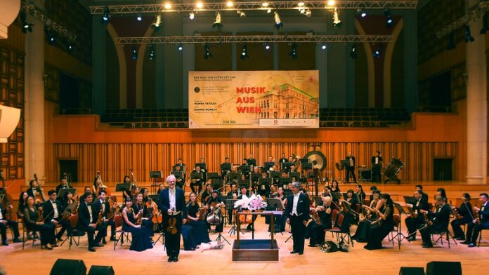 Das Bild zeigt das Orchester gemeinsam mit Rainer Honeck.