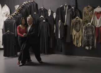 Tanzperformance Kantor-Tango / Kulturforum Warschau Das Bild zeigt ein Tanzendes Paar vor dem Hintergrund der an der Wand hängenden Kostüme vom Theaterrepertoire von Tadeusz Kantor.