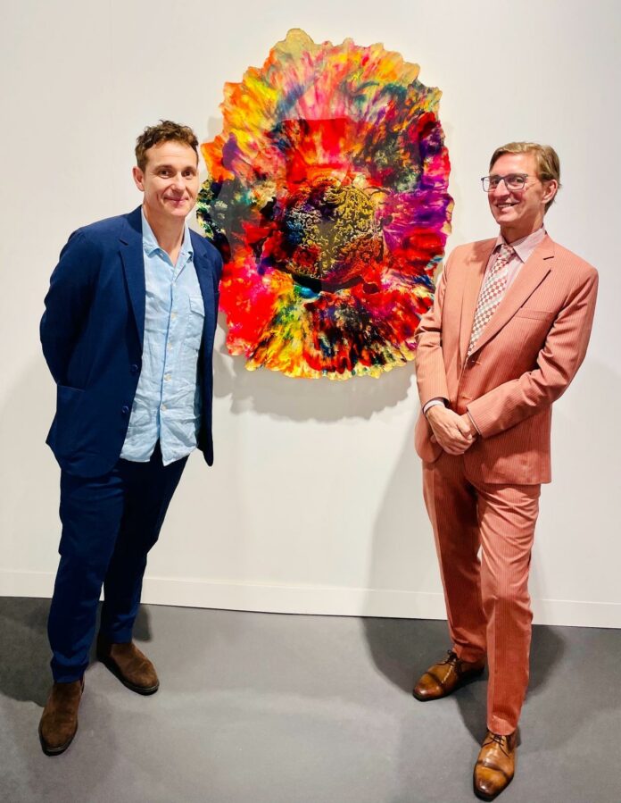 Das Bild zeigt GK Dr. Zettl mit Künstler Daniel Knorr vor einem seiner von der der Galerie Nächst St.Stephan präsentierten Werke.