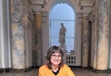 Lesereise in Estland / Botschaft Tallinn Das Bild zeigt die Autorin Karin Peschka, die auf einer Treppe sitzt.