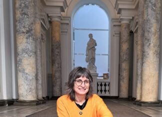 Lesereise in Estland / Botschaft Tallinn Das Bild zeigt die Autorin Karin Peschka, die auf einer Treppe sitzt.