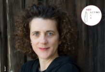 A(R)TALK 07: Olga Neuwirth / Kulturforum New York Das Bild zeigt die österreichische Komponistin Olga Neuwirth vor einer dunkelbraunen Holzwand.