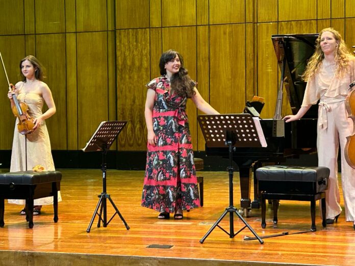 Das Bild zeigt die Künstlerinnen des Trio Immersio auf der Bühne stehend bei ihrem Auftritt bei der Johannesburg Musical Society.