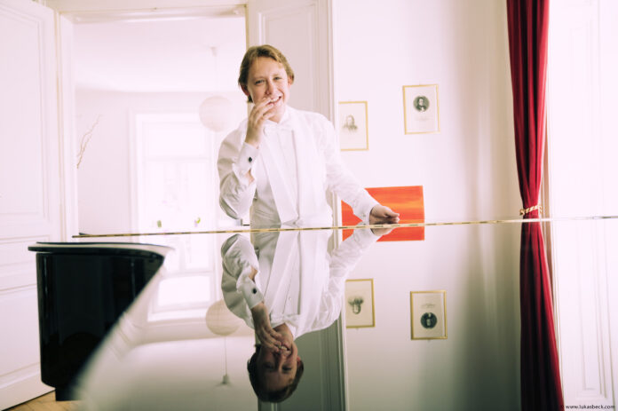Bild: © Lukas Beck Das Bild zeigt den Pianisten lächelnd am Piano.