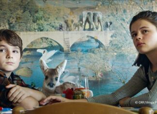 EU Filmfestival Pakistan / Botschaft Islamabad Das Bild zeigt eine Szene aus dem Film „Ein bisschen bleiben wir noch“. Zu sehen sind Oskar und Lilli, im Hintergrund eine Tapete mit Tiermotiv.