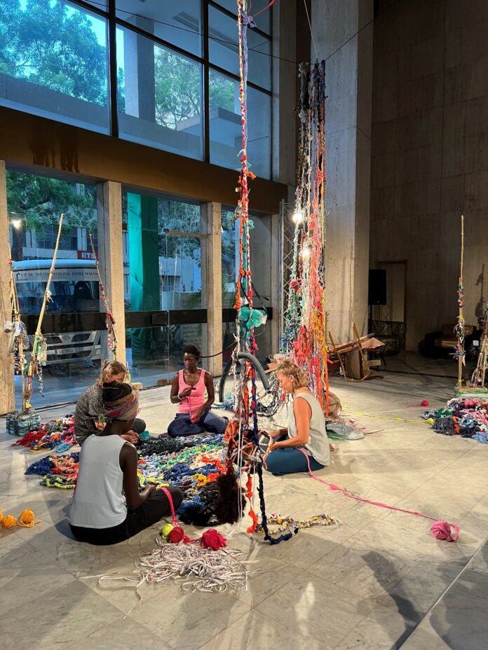 Das Bild zeigt Gudrun Lenk-Wane, Joylane Langlois, Aminata Diol und Fata Ngom im „Teatro Sorano“ anlässlich der Performance und Ausstellungseröffnung sitzend am Boden.