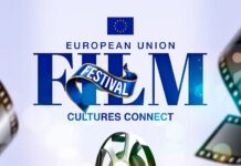 EU Film Festival – Jamaica / Kulturforum Ottawa Das Bild zeigt den Titel "European Union Film Festival" in blauer Schrift, darunter den Untertitel "Cultures Connect". Darüber hinaus ist eine Grafik eines Weltglobus zu sehen, um den herum Filmrollen angeordnet sind. Am unteren Rand des Bildes sind das Datum, der Ort und die Uhrzeit angegeben. Der Rahmen am unteren Rand des Bildes besteht aus einem schwarzen Hintergrund, auf dem die Flaggen der verschiedenen EU-Länder zu sehen sind.