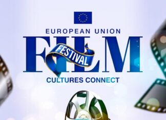 EU Film Festival – Jamaica / Kulturforum Ottawa Das Bild zeigt den Titel "European Union Film Festival" in blauer Schrift, darunter den Untertitel "Cultures Connect". Darüber hinaus ist eine Grafik eines Weltglobus zu sehen, um den herum Filmrollen angeordnet sind. Am unteren Rand des Bildes sind das Datum, der Ort und die Uhrzeit angegeben. Der Rahmen am unteren Rand des Bildes besteht aus einem schwarzen Hintergrund, auf dem die Flaggen der verschiedenen EU-Länder zu sehen sind.