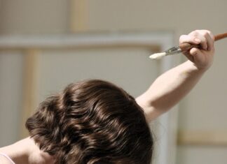 UNTER DEN STERNEN ÖSTERREICHS/ Kulturforum Rom Das Bild zeigt eine Person mit ausgestreckter Hand in der sie einen Pinsel hält. Das Standbild ist aus dem Film „Mit einem Tiger schlafen“ der Regisseurin Anja Solomonowitz.