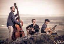 Diknu Schneeberger Trio / Botschaft Tallinn Das Bild zeigt Diknu Schneeberger, Julian Wohlmuth und Martin Heinzle in den Bergen mit Gitarre und Kontrabass musizierend