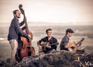 Diknu Schneeberger Trio / Botschaft Tallinn Das Bild zeigt Diknu Schneeberger, Julian Wohlmuth und Martin Heinzle in den Bergen mit Gitarre und Kontrabass musizierend