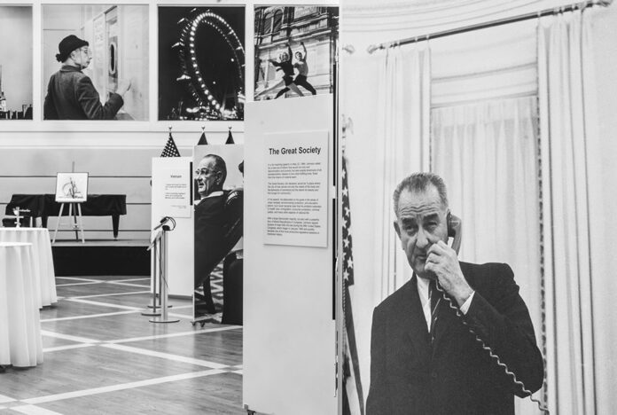 Das schwarz-weiss Bild zeigt die Ausstellung „From Vienna to The White House: Yoichi Okamoto and the American Century“. Als Hauptsujet dient ein schwarz-weiss Bild von Präsident Johnson, der gerade telefoniert.