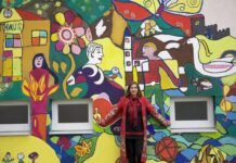 Workshop / Kulturforum Zagreb Das Bild zeigt die Künstlerin Lisa Wolf vor einer bunt bemalten Wand