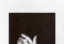 Ausstellung ’’Begegnungen’’ in Belgrad / Kulturforum Belgrad Das Bild zeigt einen dunklen Hintergrund mit zwei halbzusammengeschlossenen Händen, die eine runde Form bilden. Darauf scheint ein helles Licht.