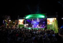 Mitrovica Int. Jazz Days 2024 / Botschaft Pristina Das Bild zeigt den Auftritt einer mehrköpfigen Jazz-Band mit vollem Publikum.