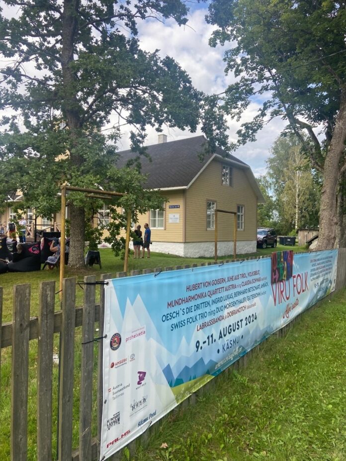 Das Bild zeigt Festivalbesucherinnen und Besucher in fröhlicher Stimmung und das Plakat des Festivals