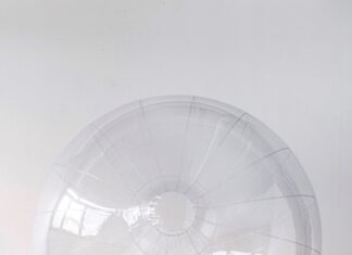 Judith P. Fischer and Uwe Hauenfels: Across Time. Form and Space. / Kulturforum New York Das Bild zeigt die Künstlerin Judith P. Fischer am Boden liegenden mit einem durchsichtigen ballartigen Kunstobjekt.