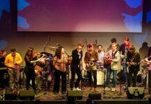 The Music Distillery Brussels / Kulturforum Brüssel Das Bild zeigt den Künstler Dominik Nostitz, sowie eine Reihe weitere Künstlerinnen und Künstler auf der Bühne während eines Auftritts der Music Distillery.