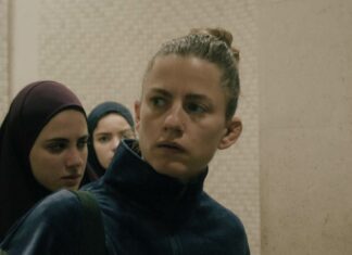 Kurdwin Ayub: „Mond“/ Kulturforum Warschau Das Bild zeigt drei Frauen – zwei mit Hijab-Kopfbedeckung und eine ohne – vor dem Hintergrund einer Mosaikwand. Dies ist ein Standbild aus dem Film Mond