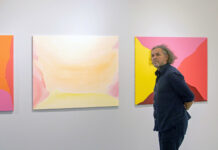 Ausstellung AMINIMAL / Botschaft Bangkok Das Bild zeigt den österreichischen Künstler Andreas Reiter Raabe vor zwei seiner Bilder