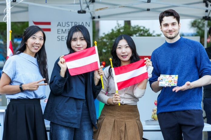 Vier Personen die vor dem Österreichischer Stand am 