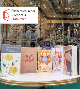 Das Bild zeigt einen Tisch mit den Finalistenbüchern des Buchpreises vor einer Kaffeehausvitrine