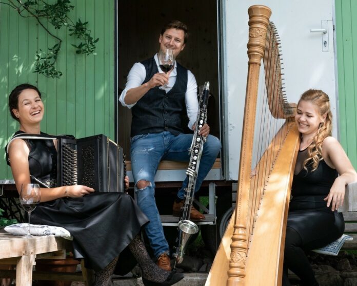 Das Bild zeigt die drei österreichischen Musiker Theresa Lehne mit Harfe, Katharina Baschinger mit steirischer Knopfharmonika und Alexander Maurer mit Bassklarinette.