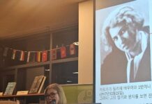 Kafkas letzte Reise / Botschaft Seoul Das Bild zeigt Professor Dr. Jang Eun-soo von der Hankuk University of Foreign Studies (HUFS) beim wissenschaftlichen Einführungsvortrag im Goethe Institut Korea. Sie steht vor einer Bücherwand und einem projizierten Bild von Kafkas Lebensgefährtin Dora Diamant