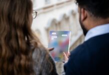 Jahrbuch/Yearbook 2023/24: imagine democratic regeneration Eine Frau und ein Mann sehen sich gemeinsam das Jahrbuch an . Man sieht sie nur von hinten.