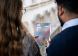 Jahrbuch/Yearbook 2023/24: imagine democratic regeneration Eine Frau und ein Mann sehen sich gemeinsam das Jahrbuch an . Man sieht sie nur von hinten.