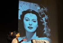 Internationale Theatertage von Karthago / Botschaft Tunis Das Bild zeigt Hedy Lamarr als Menschenpuppe während der Aufführung mit einem Kinoausschnitt im Hintergrund.