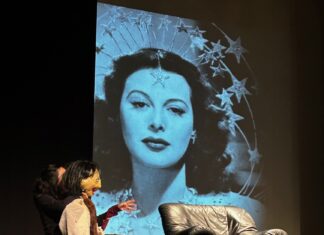 Internationale Theatertage von Karthago / Botschaft Tunis Das Bild zeigt Hedy Lamarr als Menschenpuppe während der Aufführung mit einem Kinoausschnitt im Hintergrund.