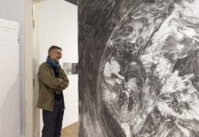 „Walk all lies away” / Kulturforum Bukarest Das Bild zeigt den Künstlern vor einer mit Bleistift gezeichneten runden Mauer, welche die Erdkugel darstellt. Er blickt nachdenklich darauf.