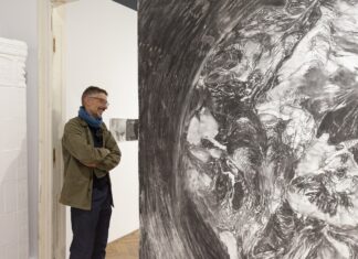 „Walk all lies away” / Kulturforum Bukarest Das Bild zeigt den Künstlern vor einer mit Bleistift gezeichneten runden Mauer, welche die Erdkugel darstellt. Er blickt nachdenklich darauf.