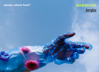 Ausstellungseröffnung Nile FLUX Das Bild zeigt eine in blaues Plastik eingewickelte Hand die vor dem Hintergrund des hellblauen Himmels in eine Richtung deutet. Auf dem Plastik befinden sich violette und lila farbene Blumen.