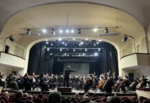 Bruckners 7. Sinfonie in Dnipro/ Kulturforum Kyjiw Es ist die Bühne mit dem Akademischen Sinfonieorchester der Dnipropetrowsk-Philharmonie. Dirigent Viktor Ploskina zu sehen, davor das Publikum.