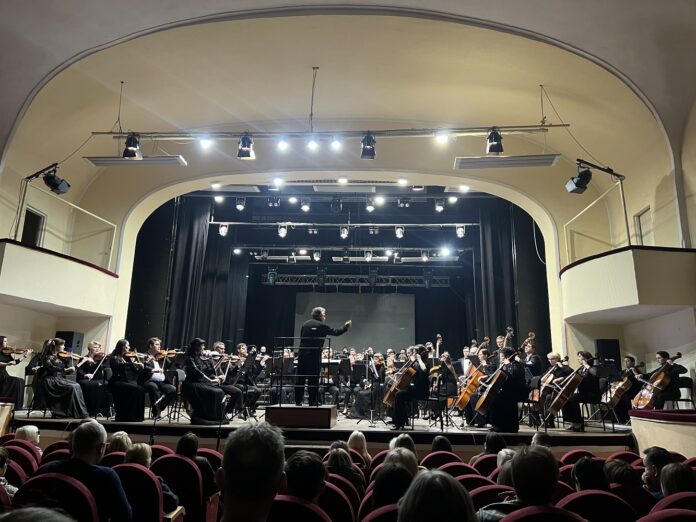 Es ist die Bühne mit dem Akademischen Sinfonieorchester der Dnipropetrowsk-Philharmonie. Dirigent Viktor Ploskina zu sehen, davor das Publikum.