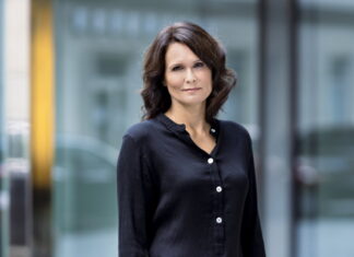 Judith Taschler in Olomouc / Kulturforum Prag Das Bild zeigt die Autorin Judith Taschler stehend und in die Kamera blickend. Sie trägt eine schwarze Bluse. Sie hat langes dunkles Haar.