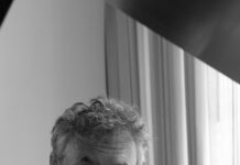 Musikalischer Abend der Solidarität mit der Ukraine/ Kulturforum New Delhi Das Bild zeigt Dr. Filenko. Er trägt ein weisses Hemd , das Foto ist schwarz weiss. Er blickt nachdenklich in die Kamera.