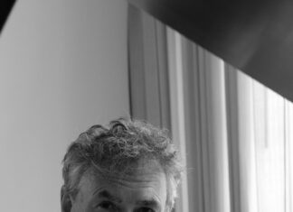 Musikalischer Abend der Solidarität mit der Ukraine/ Kulturforum New Delhi Das Bild zeigt Dr. Filenko. Er trägt ein weisses Hemd , das Foto ist schwarz weiss. Er blickt nachdenklich in die Kamera.