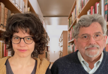 Verena Mermer & Geoff Howes / Kulturforum Washington Das Bild zeigt Verena Mermer und Geoff Howes, sie blicken gerade in die Kamera, hinter ihnen eine Bibliothek.