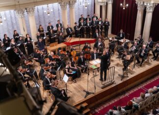 Osteroratorium und Magnificat von Johann Sebastian Bach / Kulturforum Kyjiw Es ist das Philharmonische ORchester auf der Bühne zu sehen und Georg Zwicker steht davor und dirigiert.