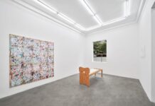 Nocturnal Animals / Generalkonsulat Shanghai Es ist die Galerie zu sehen, links ein großes buntes Bild, vorne ein kleines Bild, davor steht eine Art Holzbett.