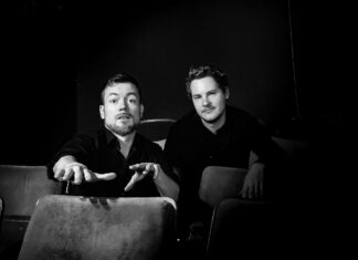 Duo Drumbadour / Kulturforum Sarajewo Das Bild zeigt die beiden Künstler sitzend in schwarz-weiß vor dunklem Hintergrund.