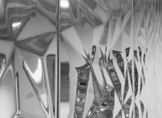 Adding Depth – Vertiefung / Kulturforum Istanbul Das Bild zeigt eine spiegelnde, geometrisch strukturierte Oberfläche mit facettierten Formen und Lichtreflexionen.