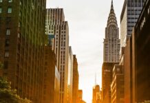 Manhattanhenge Jazz Lounge / Kulturforum New York Sonnenuntergang zwischen den Hochhäusern Manhattans: Die untergehende Sonne scheint genau entlang der Ost-West-Straße und taucht die Szene in goldenes Licht – ein Naturphänomen, das als „Manhattanhenge“ bekannt ist.