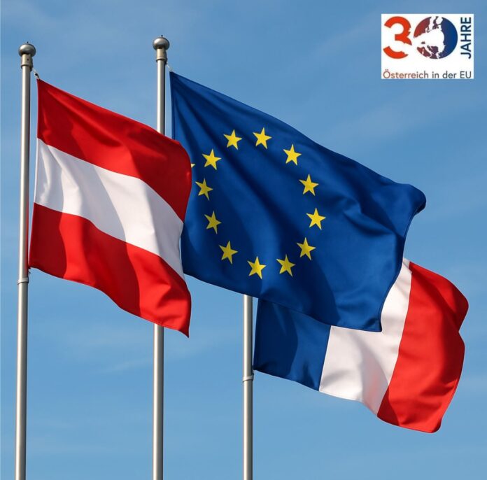 AI Das Bild zeigt die österreichische, die französische und die EU-Flagge wehend im Wind.