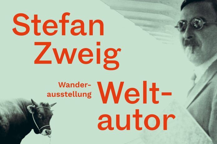 Bild: © Österreichische Nationalbibliothek Das Bild zeigt das Plakat der Wanderausstellung „Stefan Zweig. Weltautor“, auf dem Stefan Zweig (rechts) und eine Kuh (links) zu sehen sind. Zwischen ihnen steht der Titel der Ausstellung.