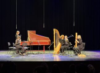 airborne extended in Istanbul / Kulturforum Istanbul Das Bild zeigt die Musikerinnen des Ensembles airborne extended bei einer Aufführung. Sie spielen verschiedene Instrumente wie Flöte, Harfe, Cembalo und Elektronik. Die Aufnahme ist in Schwarz-Weiß und zeigt eine konzentrierte Stimmung auf der Bühne.
